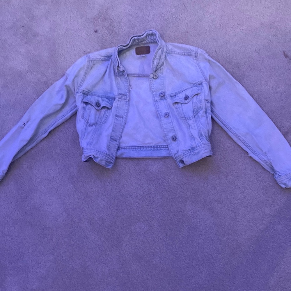 This is a light blue jeans jacket with slight rips in it that is the design